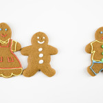 Frowning male gingerbread cookie standing separate from happy gi